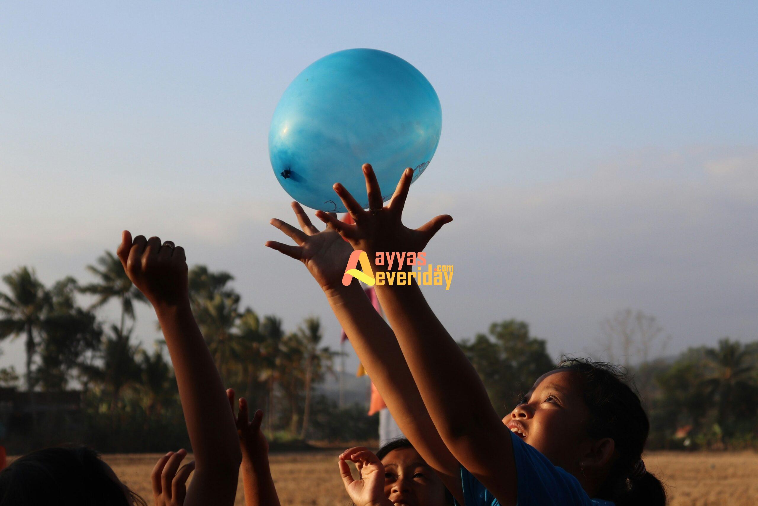 woman in black tank top holding blue balloon during daytime