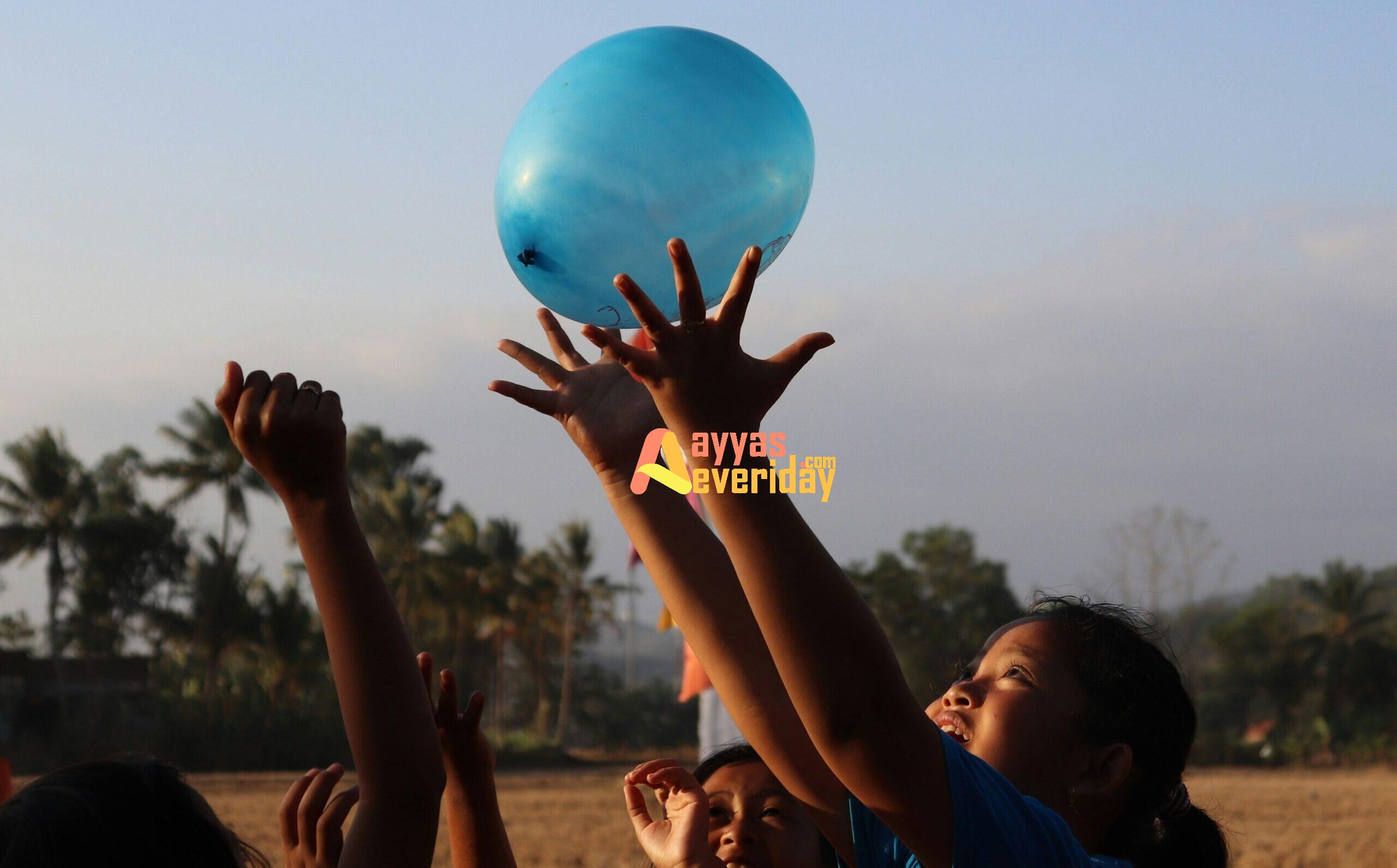 woman in black tank top holding blue balloon during daytime